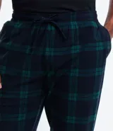 Pantalón de pijama de franela con estampa cuadrillé en tonos azul y verde. Tiene puños elásticos en los tobillos y cordón ajustable en la cintura.