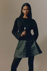 Top de manga larga de punto interlock pesado en color negro, con hombros caídos, escote redondo, pinzas moldeadoras en la cintura y bajo acampanado.