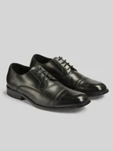 Zapato formal acordonado de cuero color negro, con costuras a la vista en la puntera y suela baja.