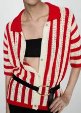Cardigan de punto calado con diseño de rayas verticales en color rojo y crema. Presenta cuello camisero, cierre frontal con botones y mangas tres cuartos.
