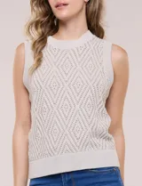 Chaleco tejido de punto calado melange, marca Elie Tahari, de color blanco. Presenta silueta semi entallada, escote a la base ligeramente elevado con terminación en punto acanalado, y sisas marcadas y ribeteadas en canalé. Confeccionado en tejido de punto con trama labrada y calados geométricos en forma de rombos, con espalda de tejido continuo y ruedo recto de largo a la cadera alta terminado en pretina ancha acanalada.