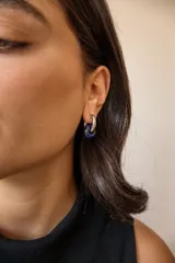Aros de argolla en acero quirúrgico con dije de piedra natural en tono azul.