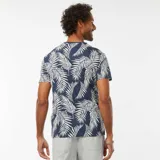Camiseta de manga corta azul con estampado de hojas de palmera blancas.