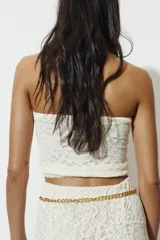 Top crop de encaje con diseño strapless y escote recto.