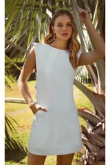 Vestido corto blanco con solapas tipo sastre, sin mangas y con bolsillos laterales.