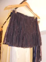 Pollera corta de tiro medio-bajo, color bordó, con volado en el ruedo y cinto integrado con detalle de lentejuelas.