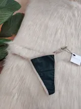 Microtanga de algodón en color verde oscuro con bordes y elásticos en tono beige.