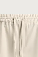 Pantalón regular fit color negro de tejido con viscosa, con cintura elástica ajustable con cordón, bolsillos frontales y traseros.