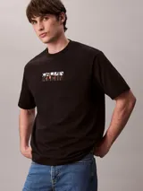 Remera Calvin Klein negra de corte relajado, manga corta y cuello redondo. Presenta un gráfico abstracto estampado en bloques con el logo de la marca en el pecho.