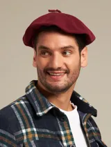 Boina azul marino de paño con visera pequeña y botón decorativo en la parte superior.