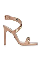 Sandalias de tacón alto color beige con tiras finas y tachas piramidales doradas.