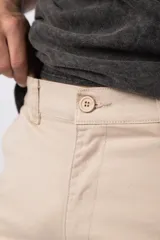 Bermuda cargo de gabardina con bolsillos laterales amplios con solapa y broche metálico. Presenta cintura con pasadores para cinturón y etiqueta tejida decorativa en uno de los bolsillos.