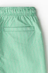 Short de baño a rayas verticales verdes y blancas, con cintura elástica y cordón de ajuste verde.