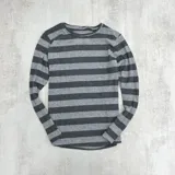 Buzo fino gris oscuro a rayas horizontales grises claras y oscuras, de manga larga y cuello redondo.