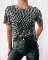 Remera de fiesta con lentejuelas plateadas formando un patrón de rombos. Incluye top negro de breteles finos para usar debajo.