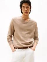 Sweater de punto Tommy Hilfiger con cuello en V, manga larga y puños y bajo acanalados. Presenta un diseño liso en color beige con el logo de la marca bordado en el pecho.