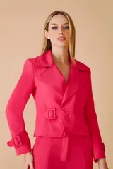 Blazer fucsia con cuello solapa, corte entallado, cierre cruzado con hebilla y mangas largas con hebilla decorativa en los puños.