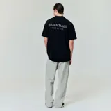 Camiseta negra de algodón con cuello redondo y corte oversize. Estampado con el logo "ESSENTIALS FEAR OF GOD" en el pecho.