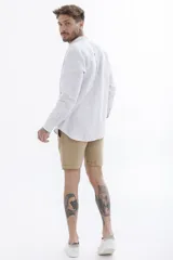 Camisa celeste a rayas verticales blancas, de manga larga y corte clásico.