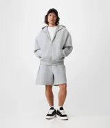 Campera boxy de malla scuba color gris melange, con capucha, cierre frontal completo y bolsillos laterales ocultos.