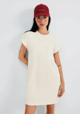 Vestido corto amarillo con cuello redondo, mangas cortas con dobladillo y bolsillo de parche en el pecho.