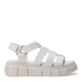 Sandalias de estilo gladiador con plataforma dentada, confeccionadas en cuero negro con tiras entrecruzadas y ajuste mediante velcro en el talón.