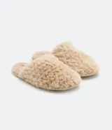 Pantufla cerrada de mujer confeccionada en tejido de poliéster con textura de pelo sintético en color negro, con suela de goma termoplástica.