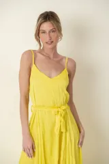Vestido largo amarillo de satén con breteles finos, corte en la cintura y lazo.