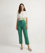 Pantalón de corte fluido y cintura media con cordón ajustable. Presenta diseño liso con bolsillos laterales y confección en tejido de viscolino.