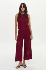 Pantalón de punto color bordó con diseño geométrico y estructura calada, de corte ancho y relajado.