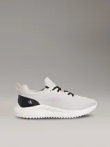 Zapatillas Calvin Klein modelo Eva Runner de color gris, confeccionadas en malla técnica transpirable con detalles en negro y salmón. Presentan suela blanca de EVA ultraligera, cordones negros y el logo 'cK' en el talón.