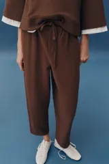Pantalón balloon de algodón color crudo, con tiro medio, cintura elástica ajustable con cordón y bolsillos laterales.