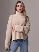 Sweater de tejido grueso con cuello alto, corte relajado y mangas largas. Presenta una textura acanalada y un diseño minimalista con etiqueta distintiva de la marca en el ruedo.