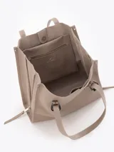 Bolso tipo tote de cuero color tostado con doble asa de hombro, detalles de hebillas metálicas en el frente y cierres laterales decorativos.