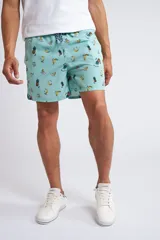 Short de baño con cintura elástica y cordón ajustable, confeccionado en tela ligera de secado rápido. Presenta un estampado botánico integral en tonos amarillos, blancos y azules, con dos bolsillos delanteros y uno posterior.