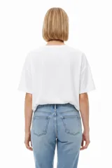 Remera de algodón blanca, de manga corta, cuello redondo y diseño holgado con estampa en el pecho.