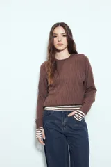 Sweater de punto color negro, con cuello redondo y diseño texturizado con ondas en relieve. Presenta mangas largas y un calce cómodo y holgado.