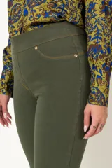 Calza verde militar de jean, sin cierre, con faja en la cintura, falsos bolsillos delanteros y bolsillos traseros con detalle de pespuntes.