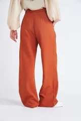 Pantalón de vestir color óxido con corte oxford, cintura con elástico, cierre frontal con botón y bolsillos laterales.