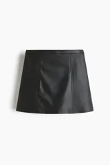 Pollera mini de corte evasé en color negro, confeccionada en material sintético con acabado tipo cuero. Presenta un diseño de cintura clásica y costuras verticales decorativas en el frente.