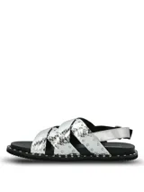 Sandalias de cuero plateado con textura de reptil, diseño de tiras cruzadas decoradas con tachas metálicas. Poseen ajuste mediante hebilla lateral y suela de goma con detalle de tachas en el borde.
