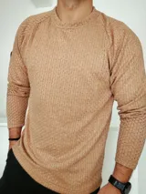 Buzo color camel de tejido texturizado con cuello redondo y mangas largas.