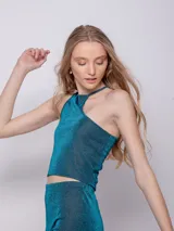 Top asimétrico de tela brillante color azul, sin mangas.