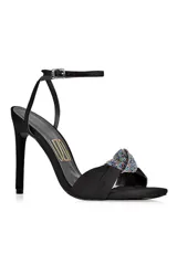 Sandalia de fiesta negra con taco aguja y pulsera al tobillo. Presenta un adorno de moño con apliques de strass multicolor en la capellada.