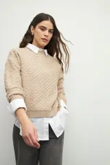 Sweater de tejido texturizado en color beige, con cuello redondo y mangas largas.