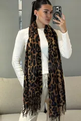 Bufanda rectangular con estampado animal print de leopardo en tonos marrones y negros, con terminación de flecos en los extremos.