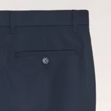Pantalón de vestir de corte slim en color azul marino, con cierre de botón y cremallera, trabillas para cinturón y bolsillos laterales.