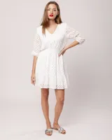 Vestido corto negro de broderie de algodón, con escote en V, mangas tres cuartos, cintura elastizada, falda corte A con volado y forro interior.