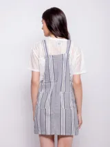 Jumper corto a rayas verticales en tonos azul y blanco, con tiras regulables, tres bolsillos y corte ajustado.