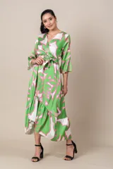 Vestido midi cruzado de satén estampado en tonos verde, blanco y rosa. Tiene lazo en la cintura, mangas 3/4 acampanadas y falda irregular con volados.